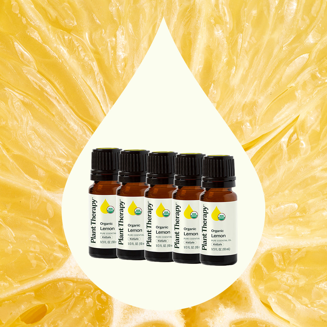 Five-pack of organic lemon essential oils centered in a white teardrop shape over fresh lemon pulp texture