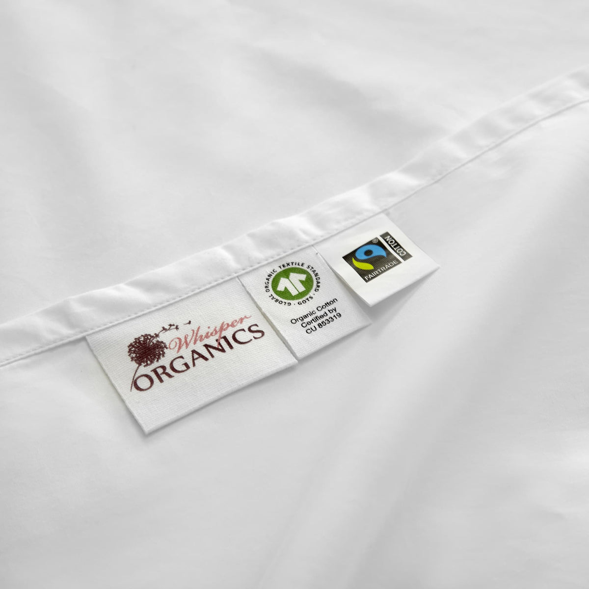 Product labels sewn into white seam displaying brand logo and GOTS Fairtrade marks