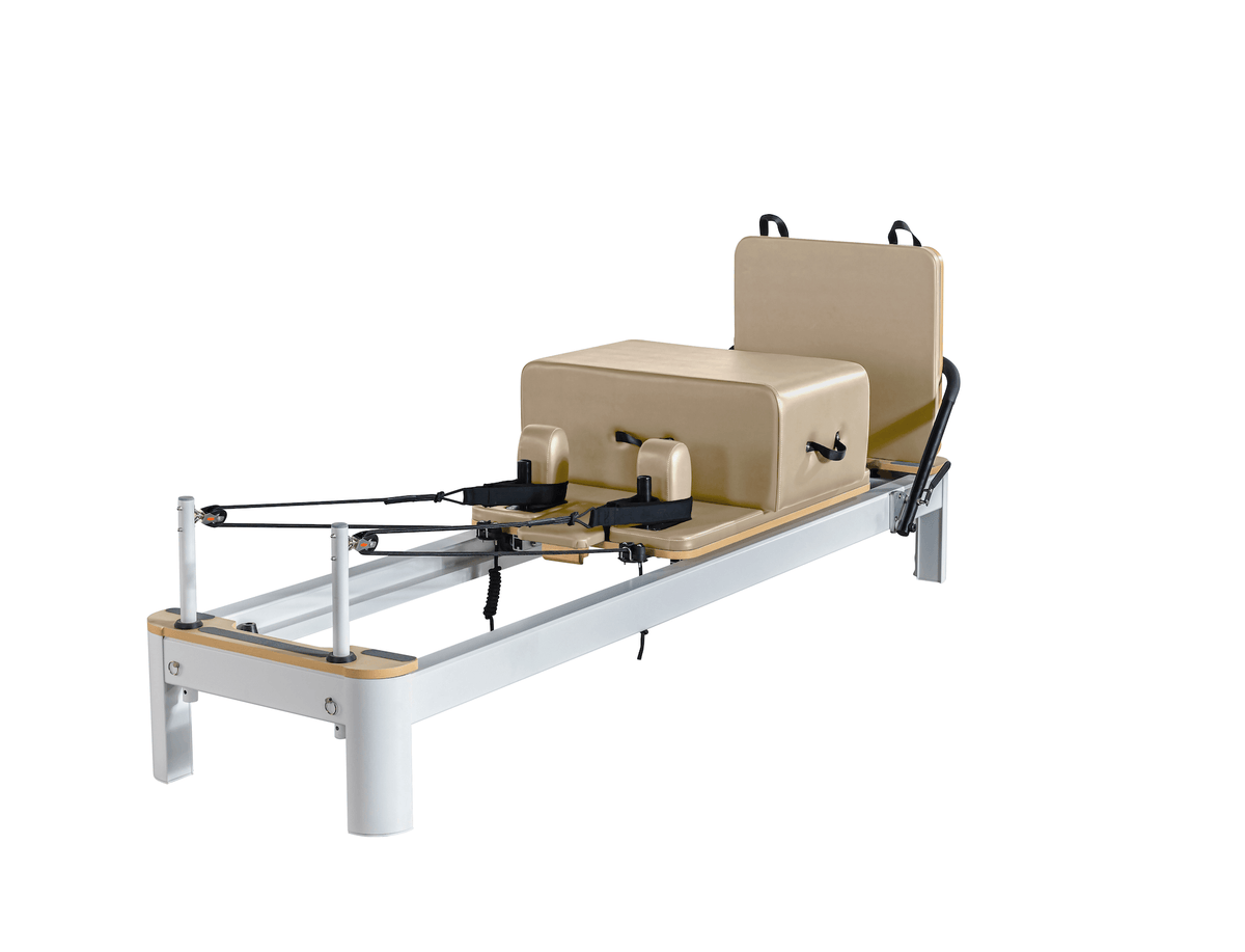 Full beige customized Pilates reformer with sliding carriage, footbar straps, and matching box on white background