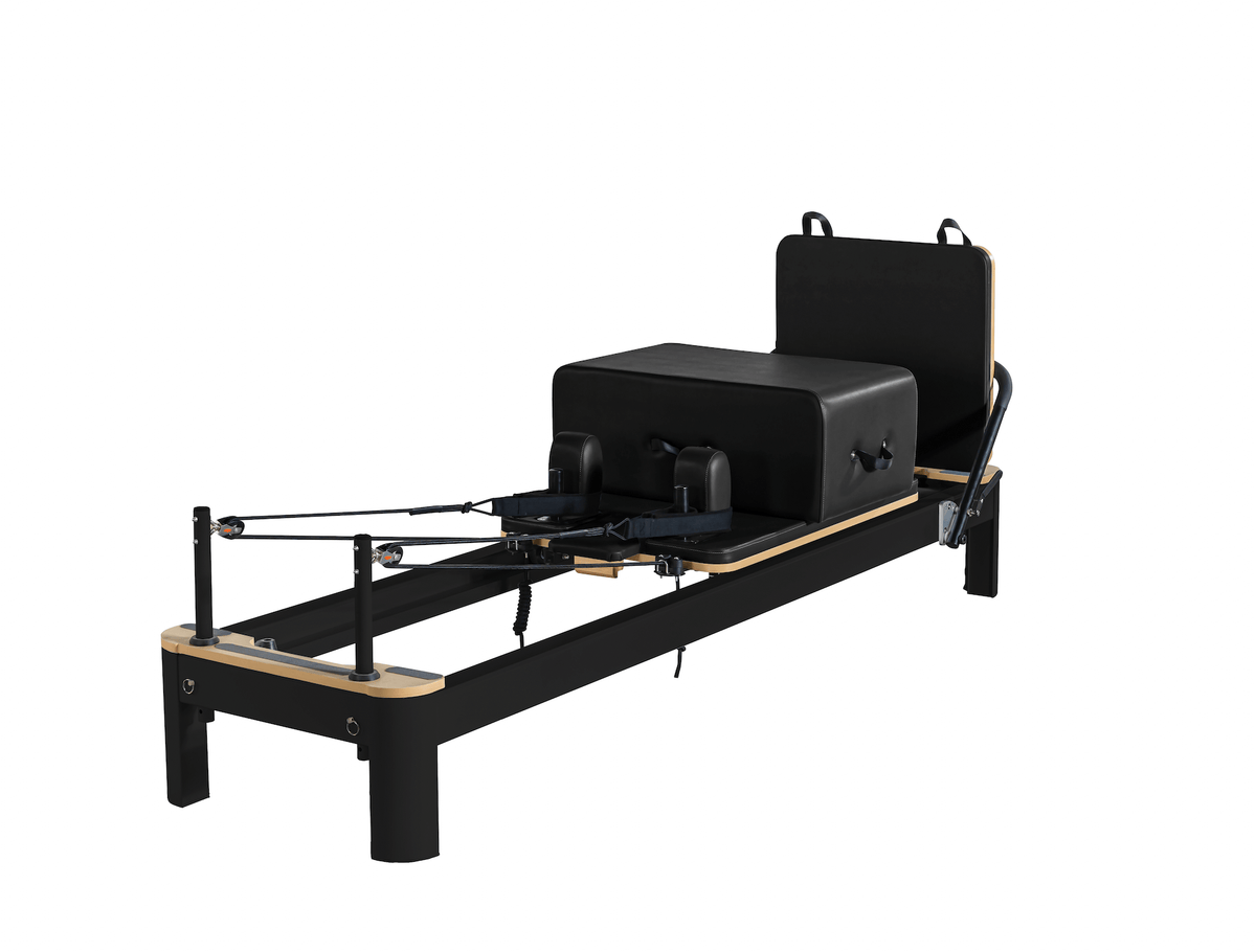 Black customized Pilates reformer with light wood trim accents, sliding carriage, and vertical standing platform