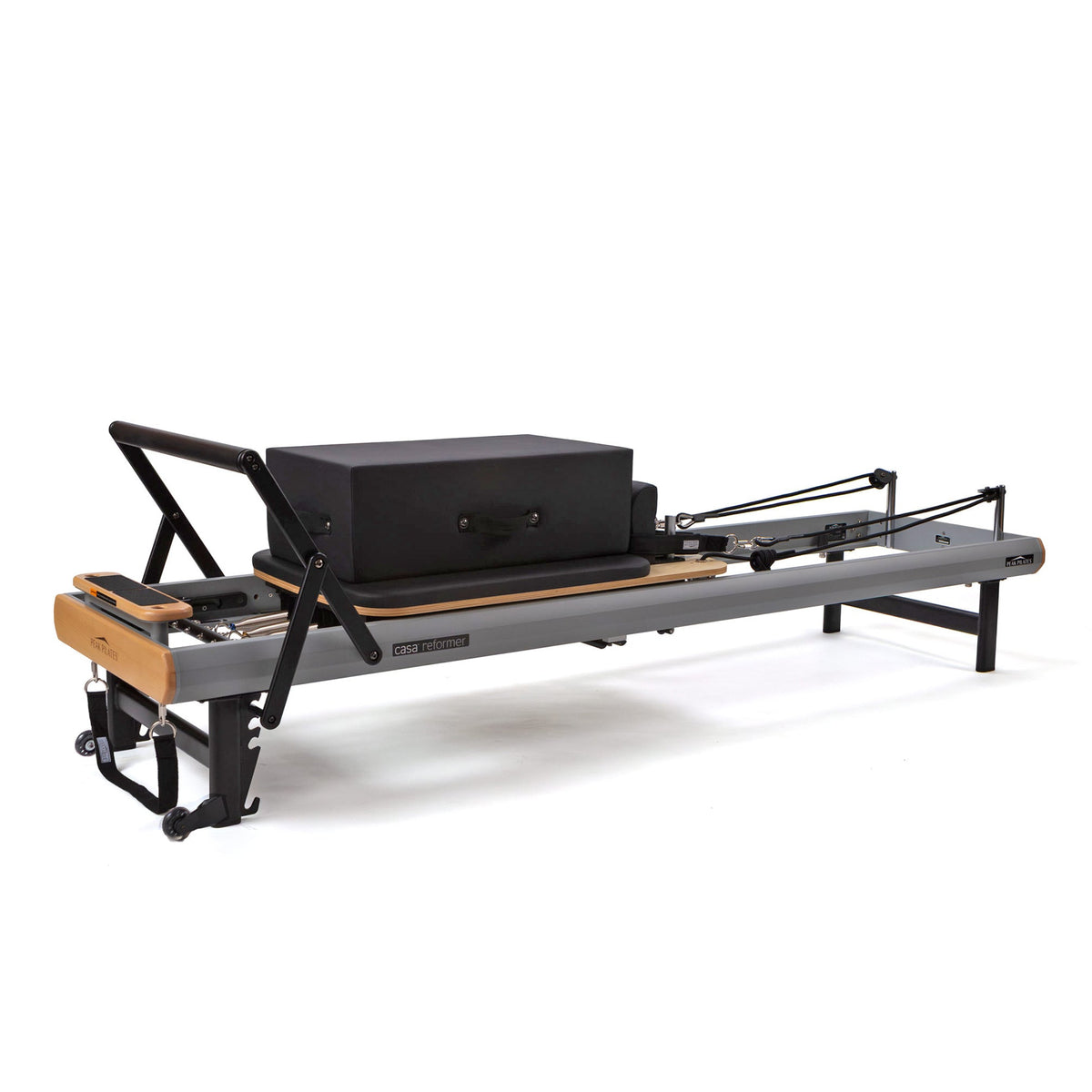 Three-quarter view of grey and wood compact Pilates reformer with large black rectangular long/short box on carriage