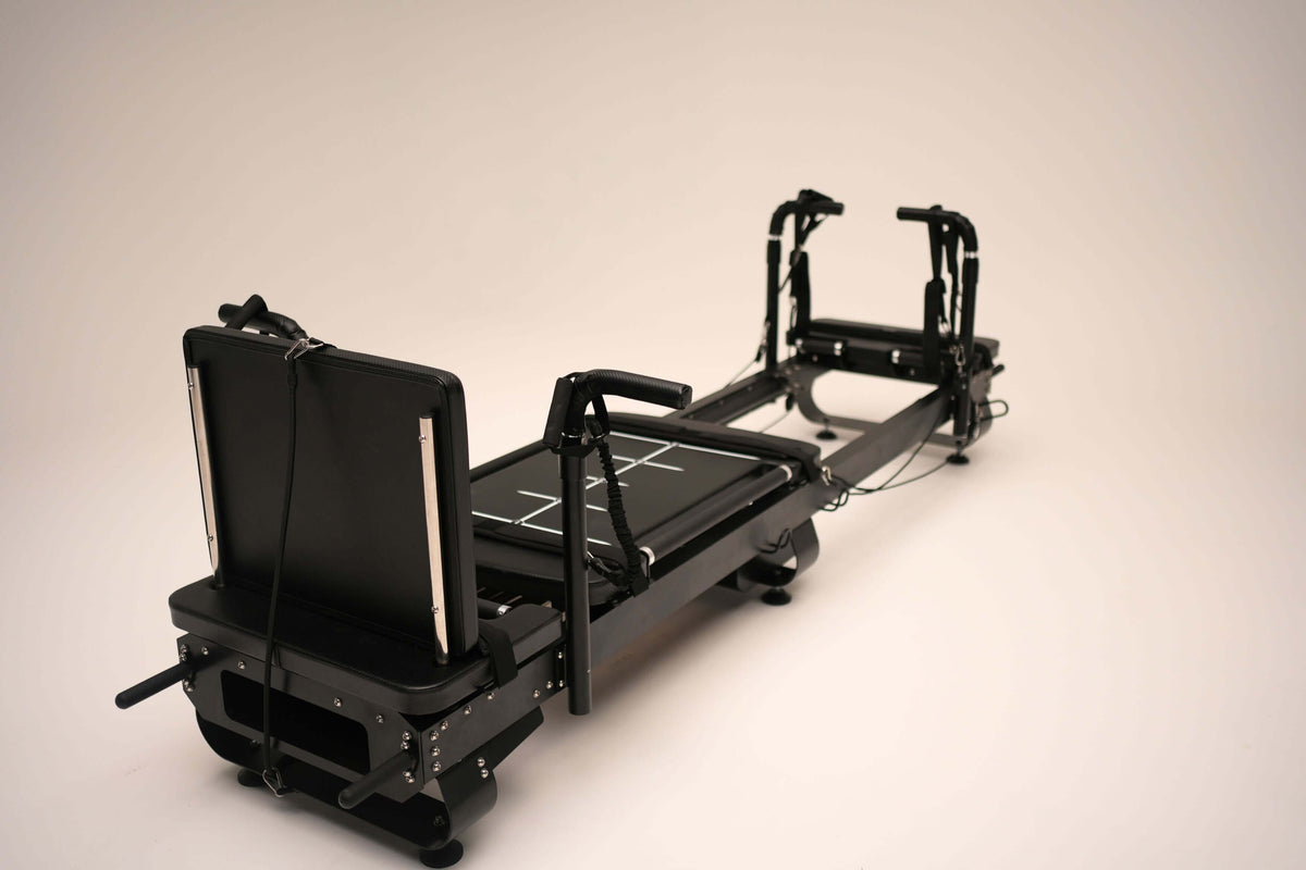 Single black Sculptformer machine against white background showing adjustable backrest, sliding carriage, and handlebars