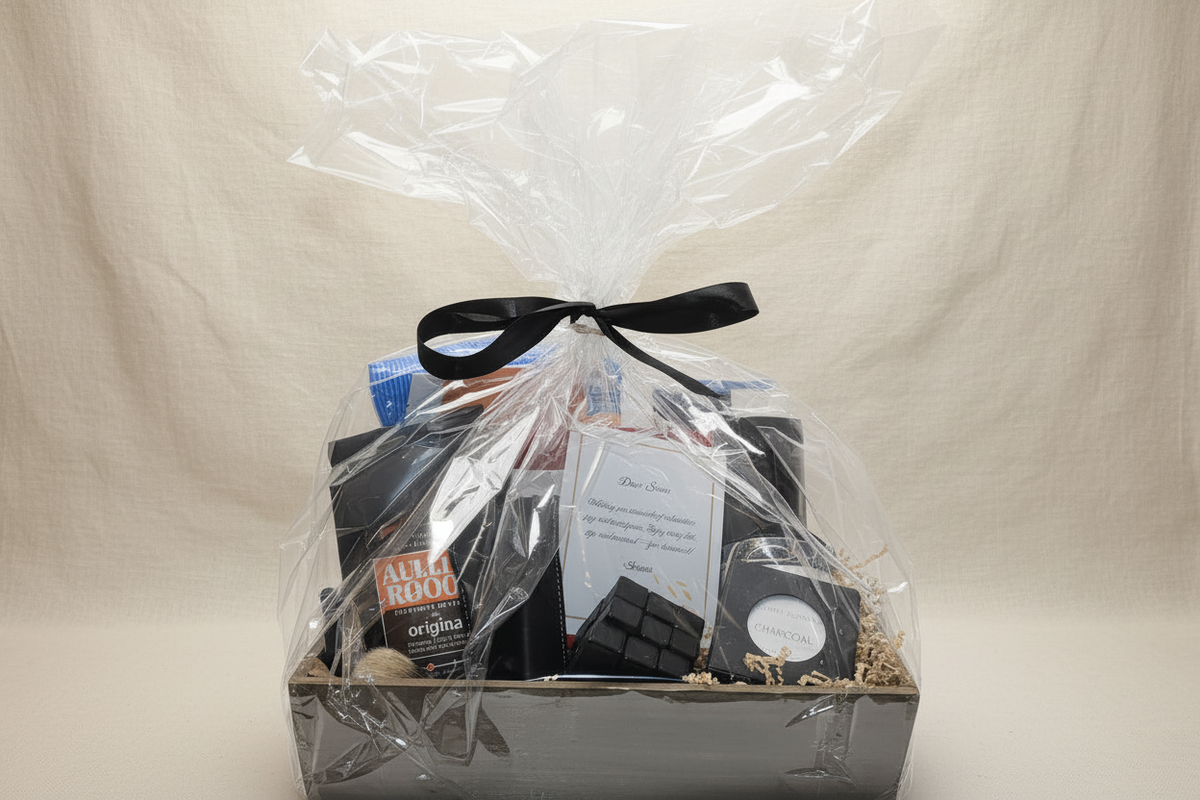 Front-facing rustic wooden crate with black ribbon holding jerky package, charcoal soap, chocolate block, and greeting card