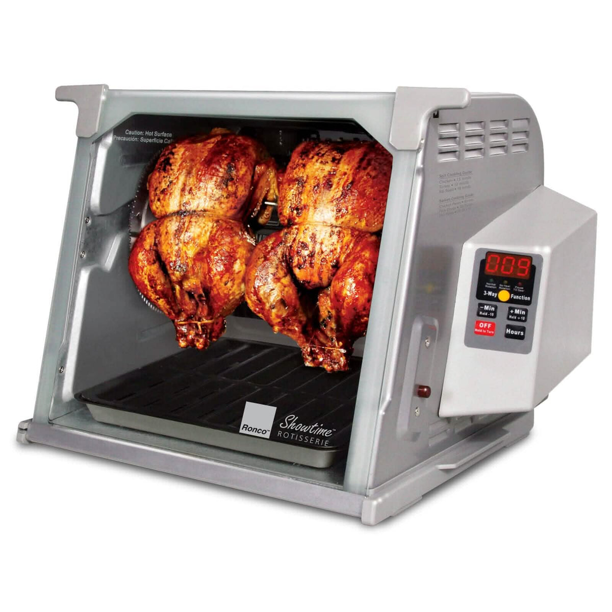 Silver Ronco rotisserie oven with four golden-brown chickens rotating inside glass chamber and digital timer display